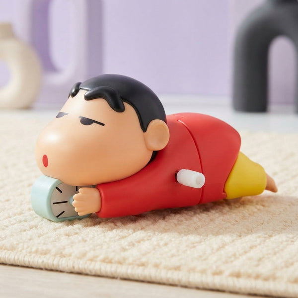 Shinchan crawling toy mid-movement on a textured cream rug with soft lavender and charcoal background.